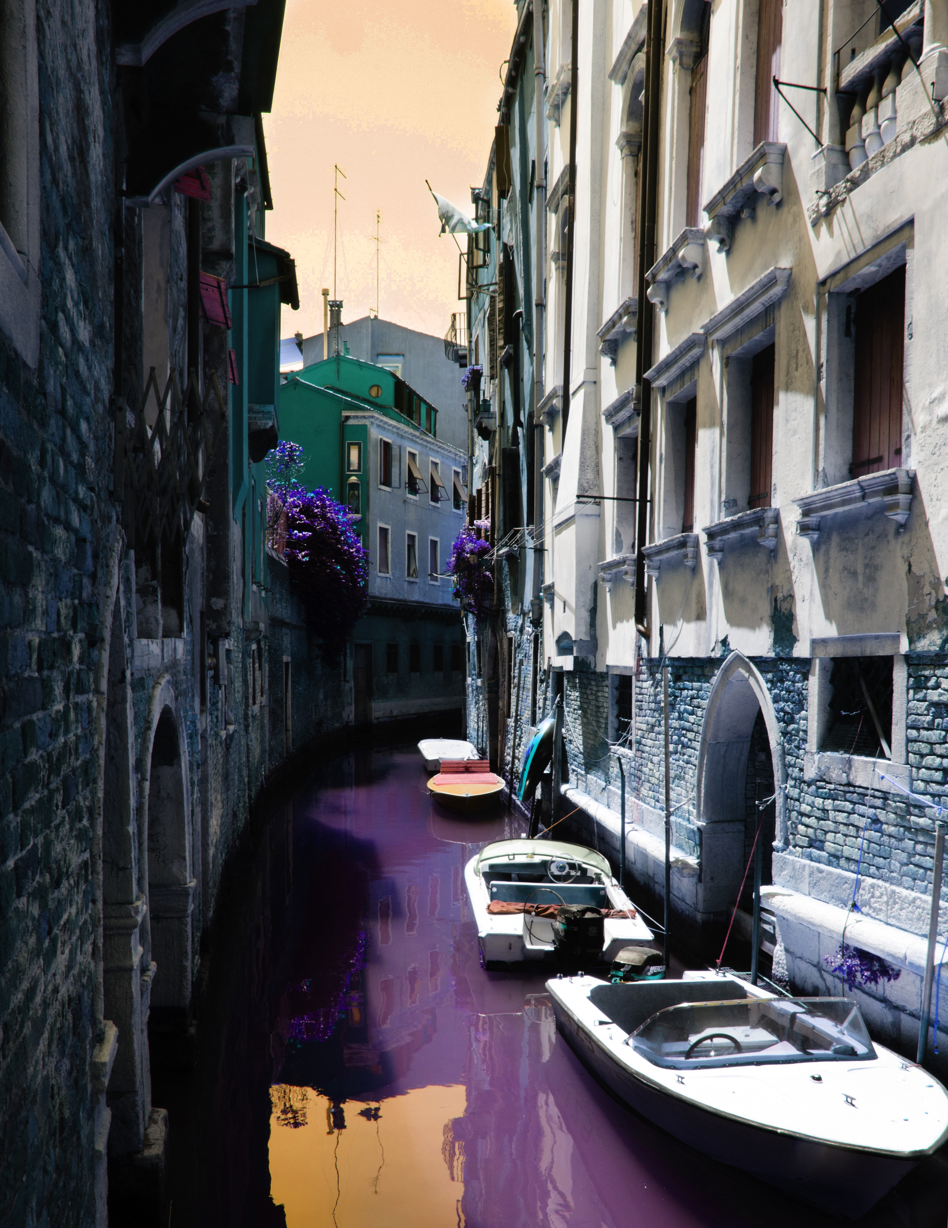 Canal urbain avec des façades anciennes, une eau violette et un ciel aux teintes pastel.