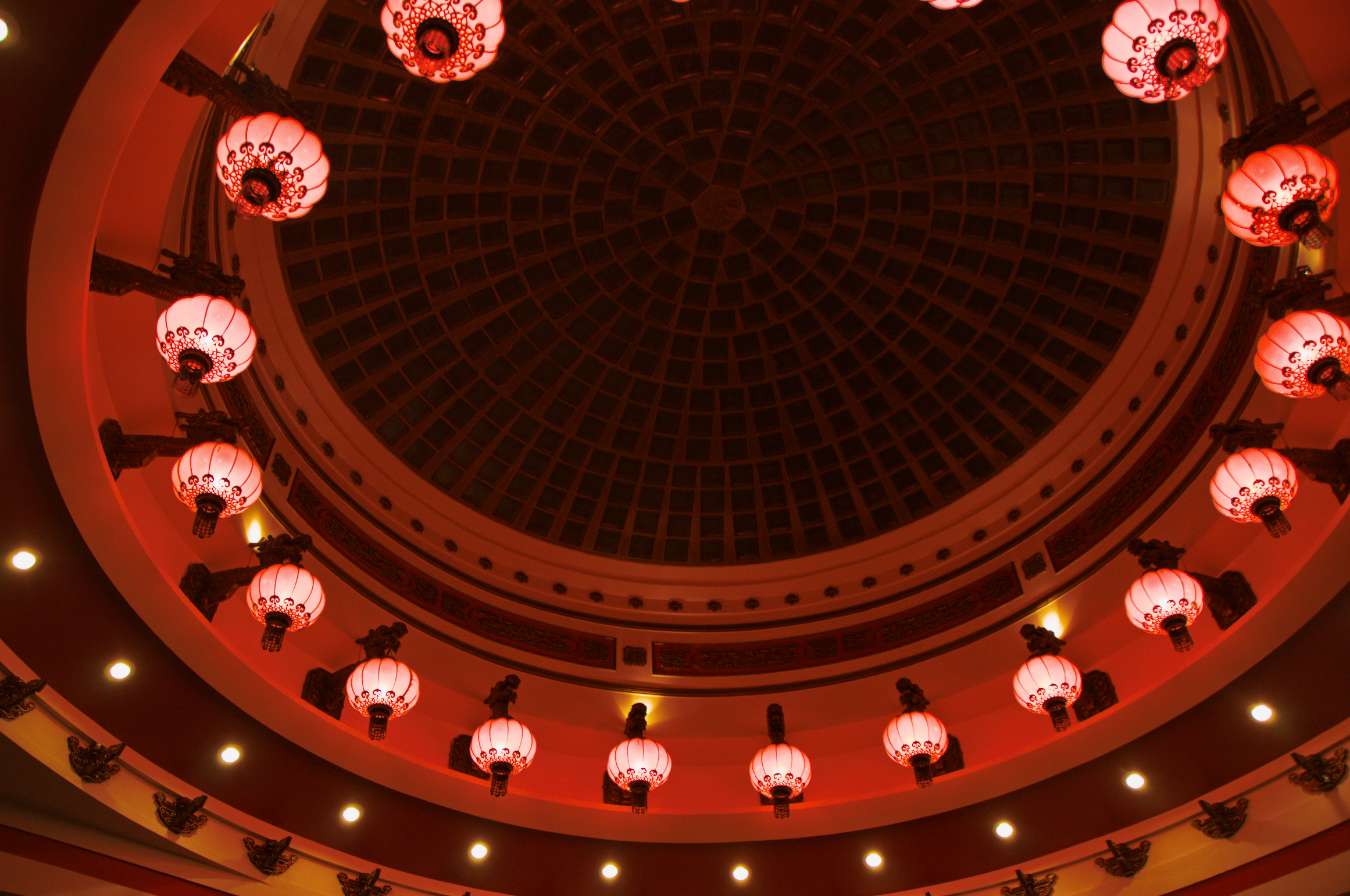 Plafond circulaire décoré de lanternes rouges dans une ambiance chaleureuse et tamisée.